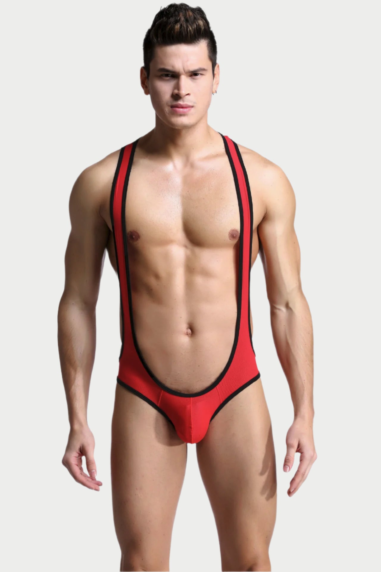 A male model wearing a red and black mesh wrestling singlet