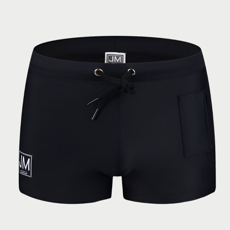 Black swimming trunks with a drawstring waist and a front pocket, featuring a white logo on the left leg.