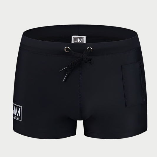 Black swimming trunks with a drawstring waist and a front pocket, featuring a white logo on the left leg.