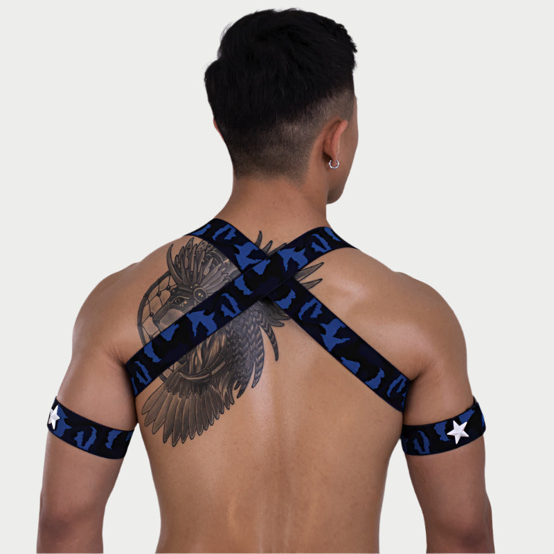 Man wearing a black and blue patterned shoulder strap on a plain background