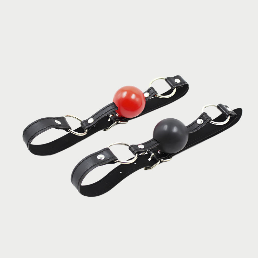 Two black faux leather ball gags with red and black balls, featuring adjustable straps.