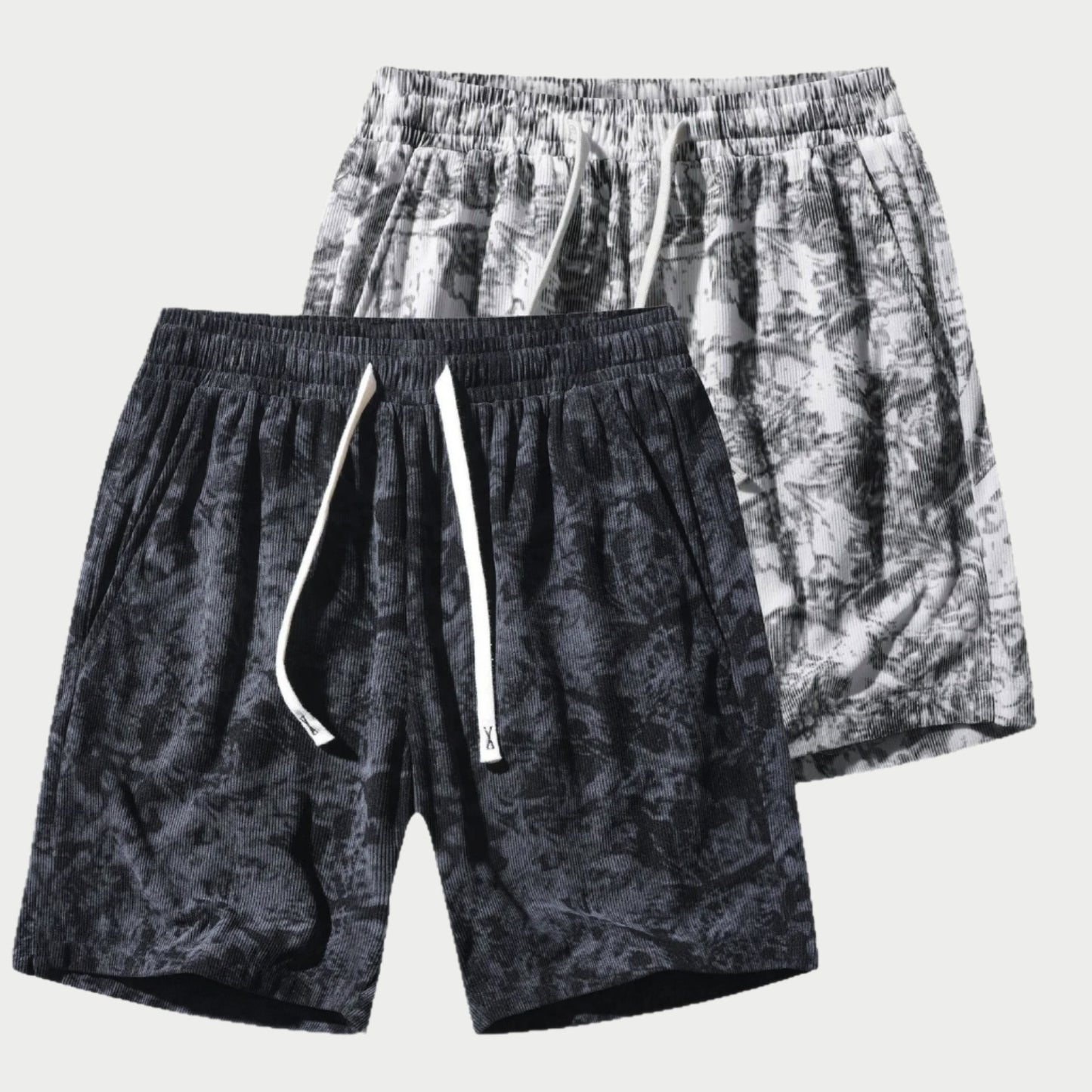 Two pairs of patterned shorts on a white background
