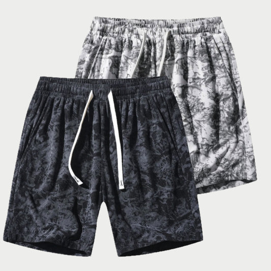Two pairs of patterned shorts on a white background