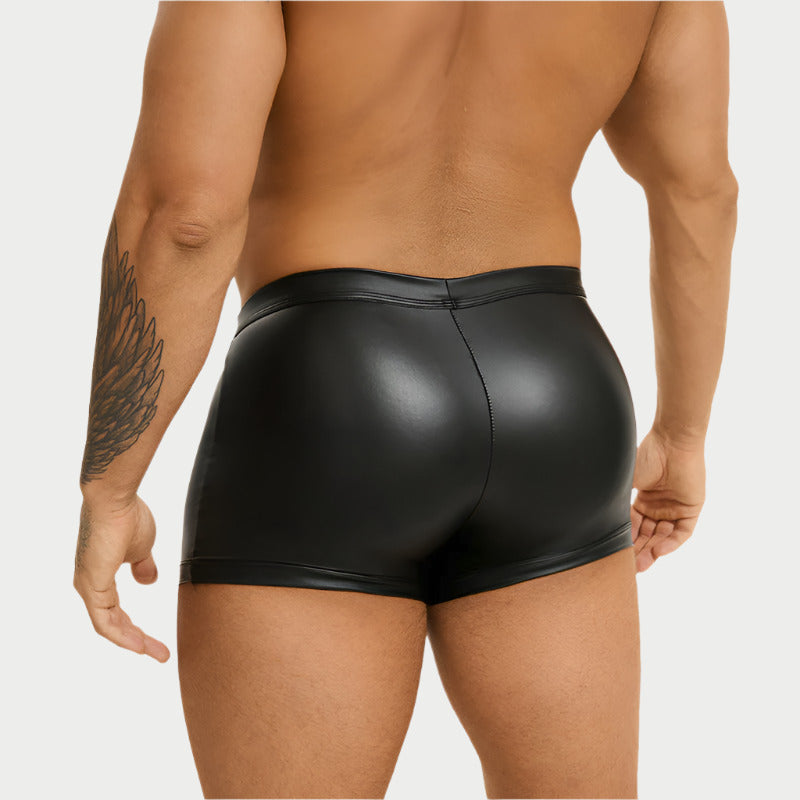Person wearing black leather shorts on a white background