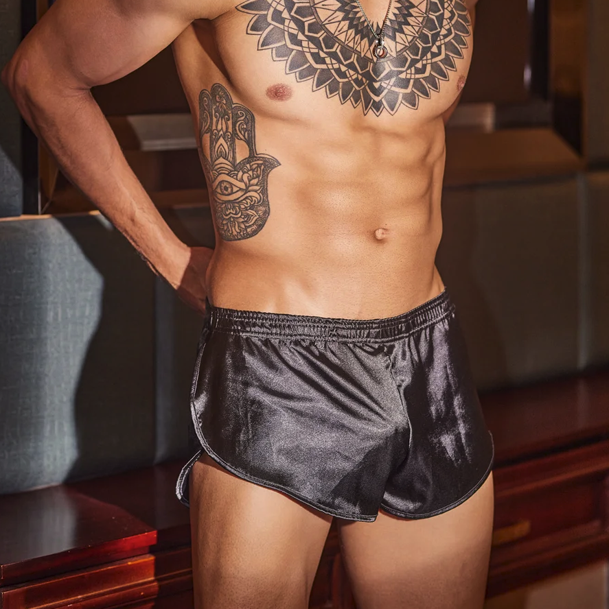 This image displays a pair of sleek, black silk jock boxers designed for a snug and comfortable fit. The model is shown wearing the boxers, which highlight their smooth texture and elastic stretch material.