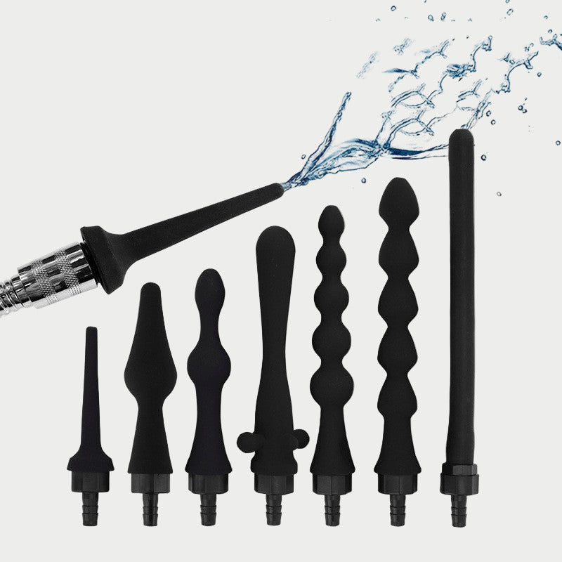 A collection of black silicone douche enema adapters of various sizes, shapes, and textures, displayed alongside a visual representation of water flowing from one of the adapters.