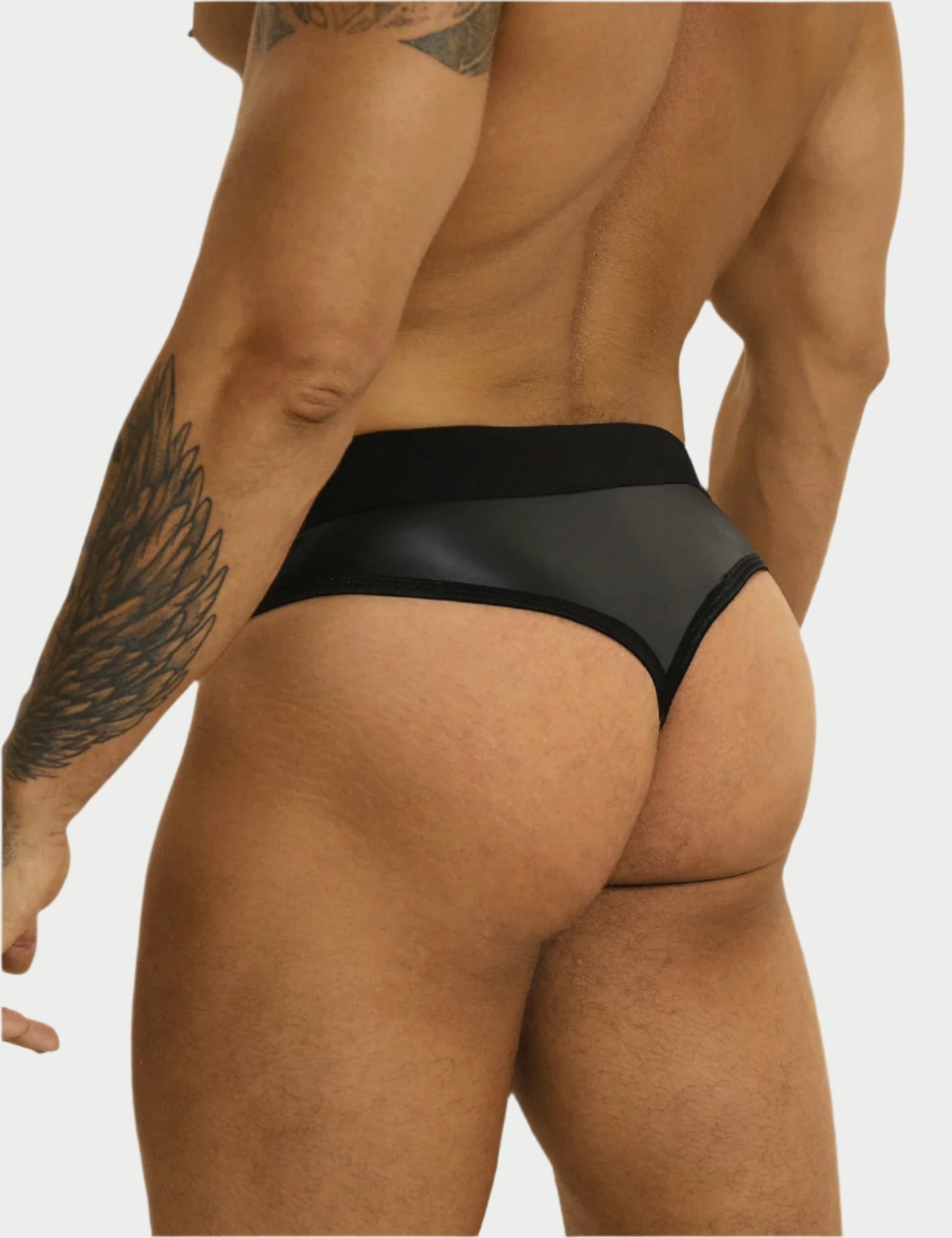 Black men's underwear being worn by a person with tattoos on a white background