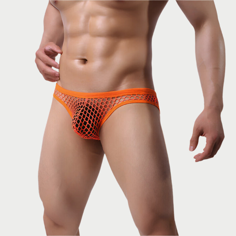 This image features a pair of striking orange mesh fishnet briefs. The model is shown wearing the briefs, which highlight a bold and trendy design with a mesh fishnet pattern that offers a distinct, edgy appearance.