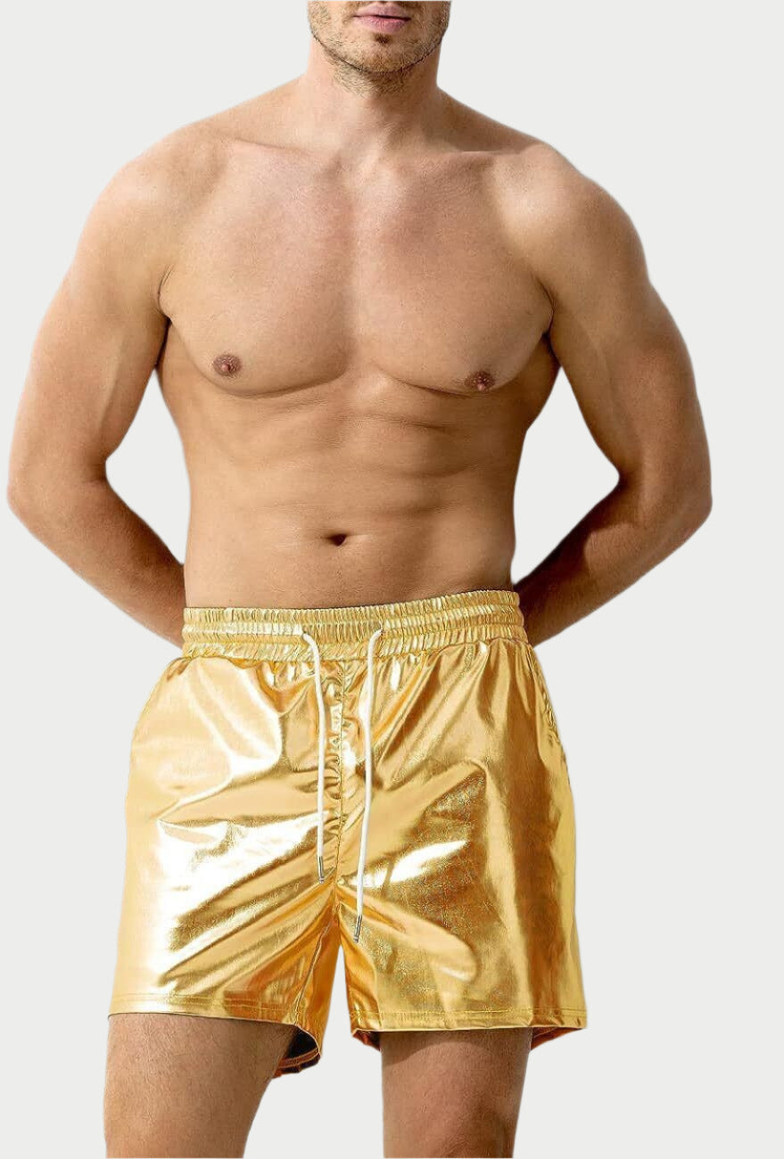A person standing against a white background, wearing gold-colored shorts with a glossy finish.