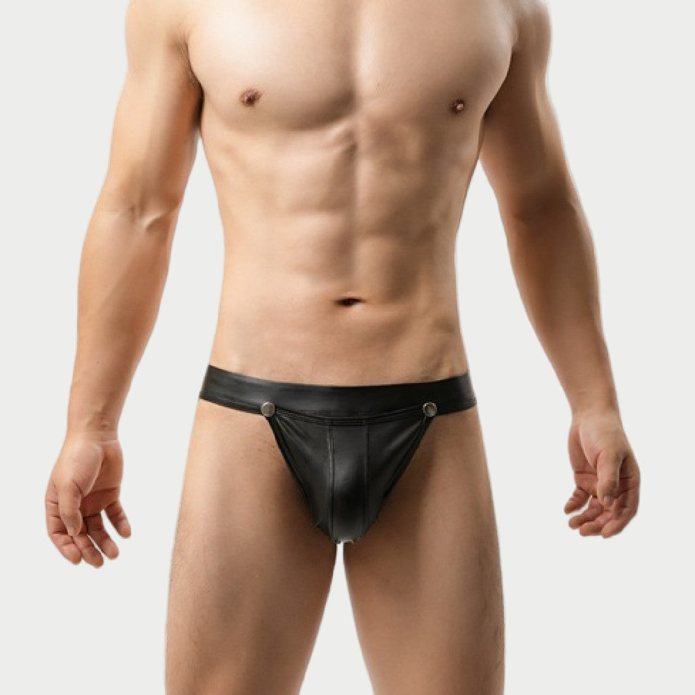 Man wearing a black leather jockstrap against a plain background