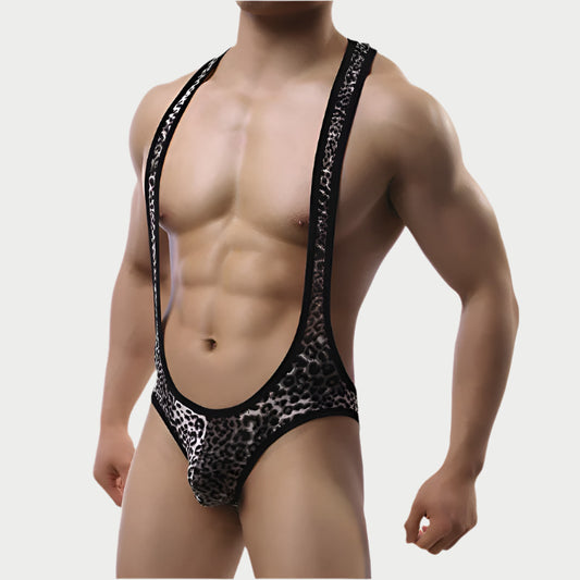 Man wearing a leopard print thong with black straps on a plain background