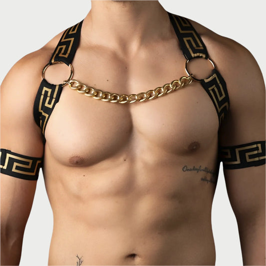 Man wearing a gold chain harness with black straps on a light blue background